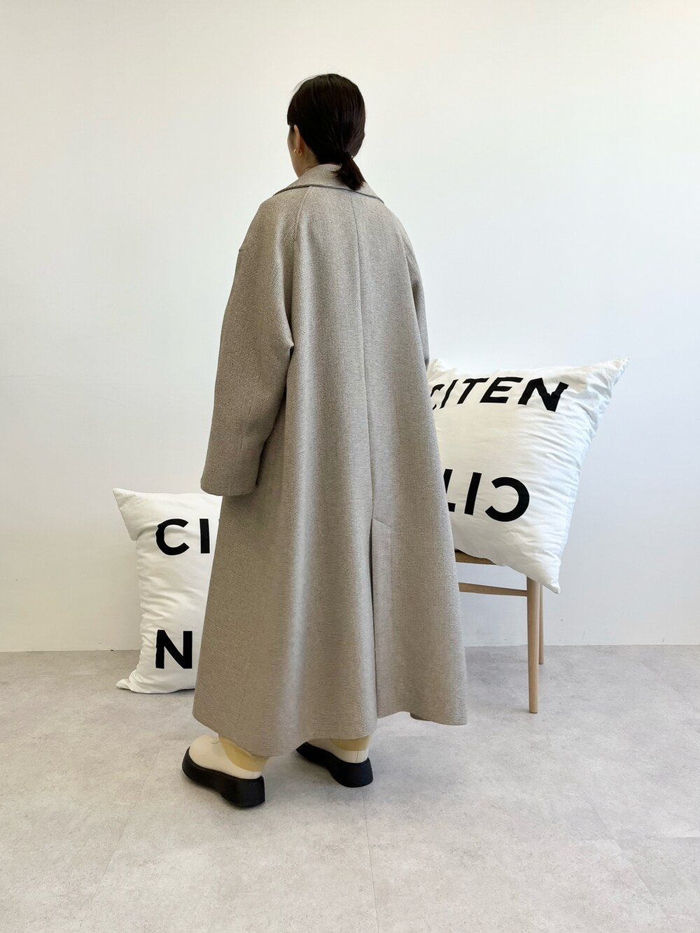 ブラウン系のステンカラーコート、ホワイト系のTシャツ/カットソー、ホワイト系のトップスを着用したレディースの秋コーディネートの3枚目の写真