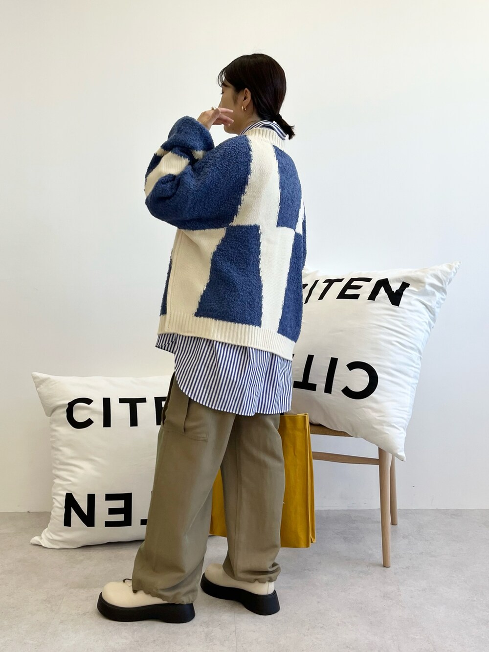 ホワイト系のトートバッグ、ホワイト系のブーツ、グリーン系のカーゴパンツを着用したレディースの秋コーディネートの3枚目の写真