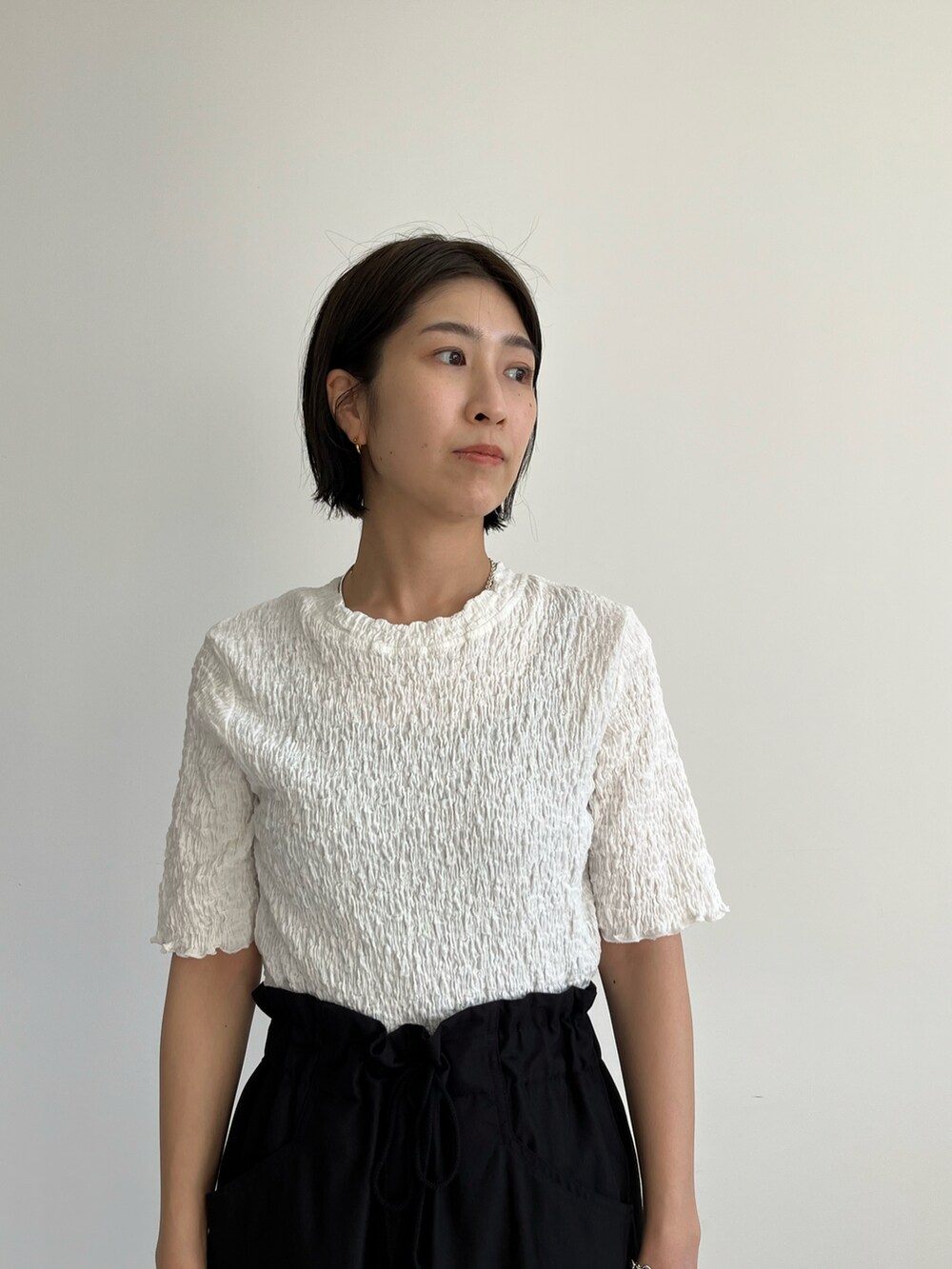 ホワイト系のTシャツ/カットソー、ブラック系のカーゴパンツ、ベージュ系のサンダルを着用したレディースの春コーディネートの3枚目の写真