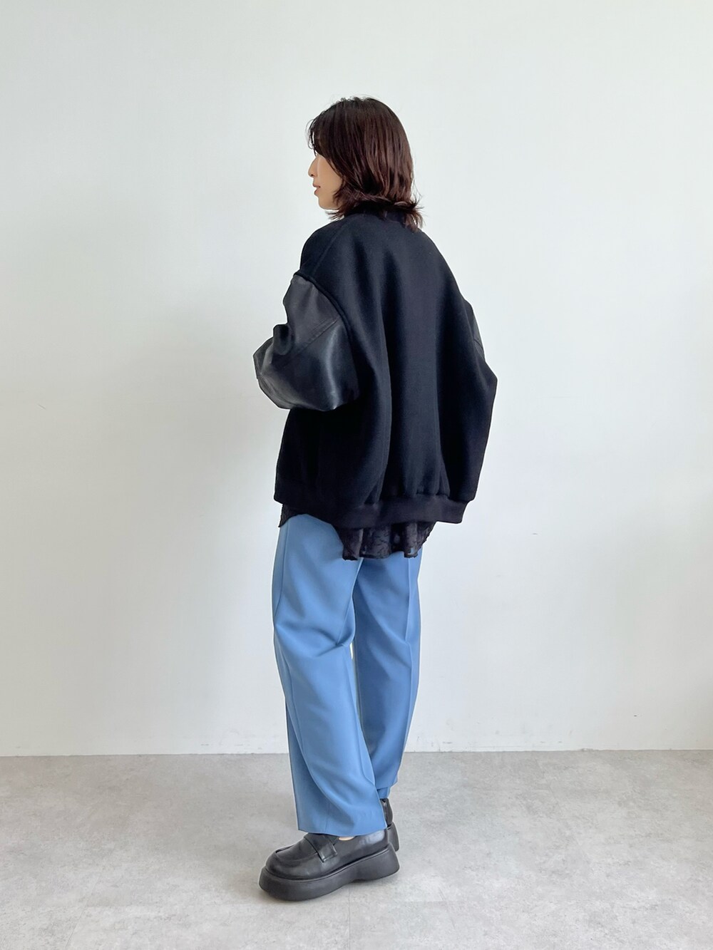 ブラック系のスタジャン、ブルー系のその他パンツ、ホワイト系のTシャツ/カットソーを着用したレディースの秋コーディネートの2枚目の写真