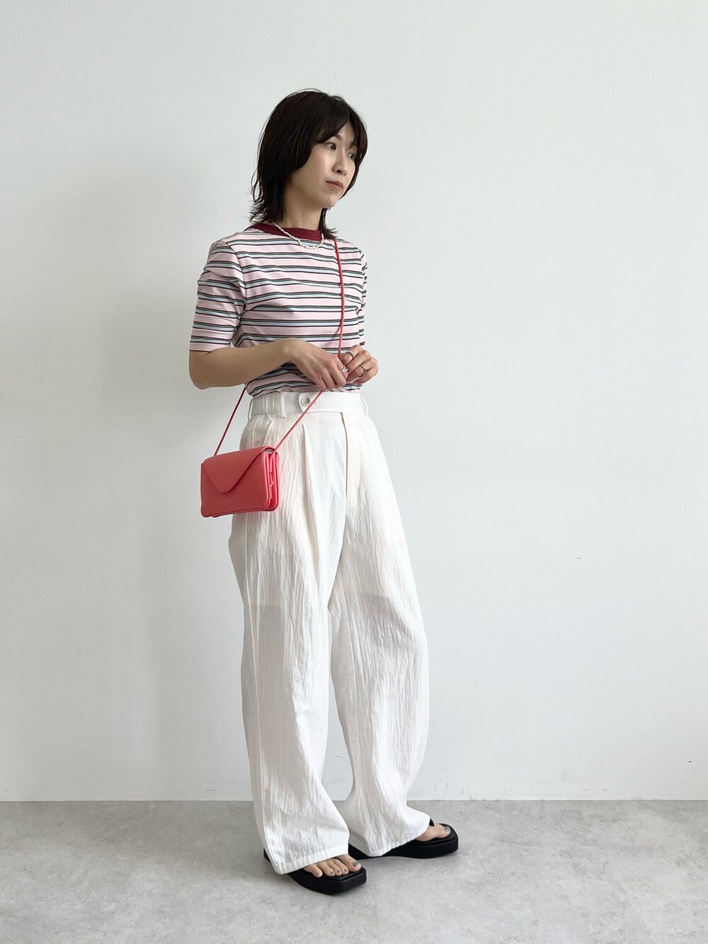 ピンク系のショルダーバッグ、ホワイト系のその他パンツ、ブラック系のサンダルを着用したレディースの春コーディネートの2枚目の写真