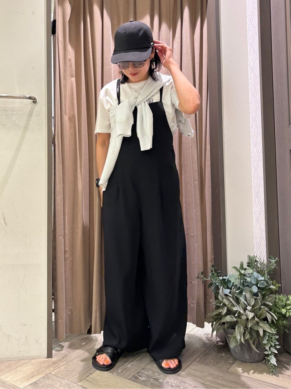 ホワイト系のカーディガン/ボレロ、ホワイト系のTシャツ/カットソー、ブラック系のサロペット/オーバーオールを着用したレディースの春コーディネートの2枚目の写真