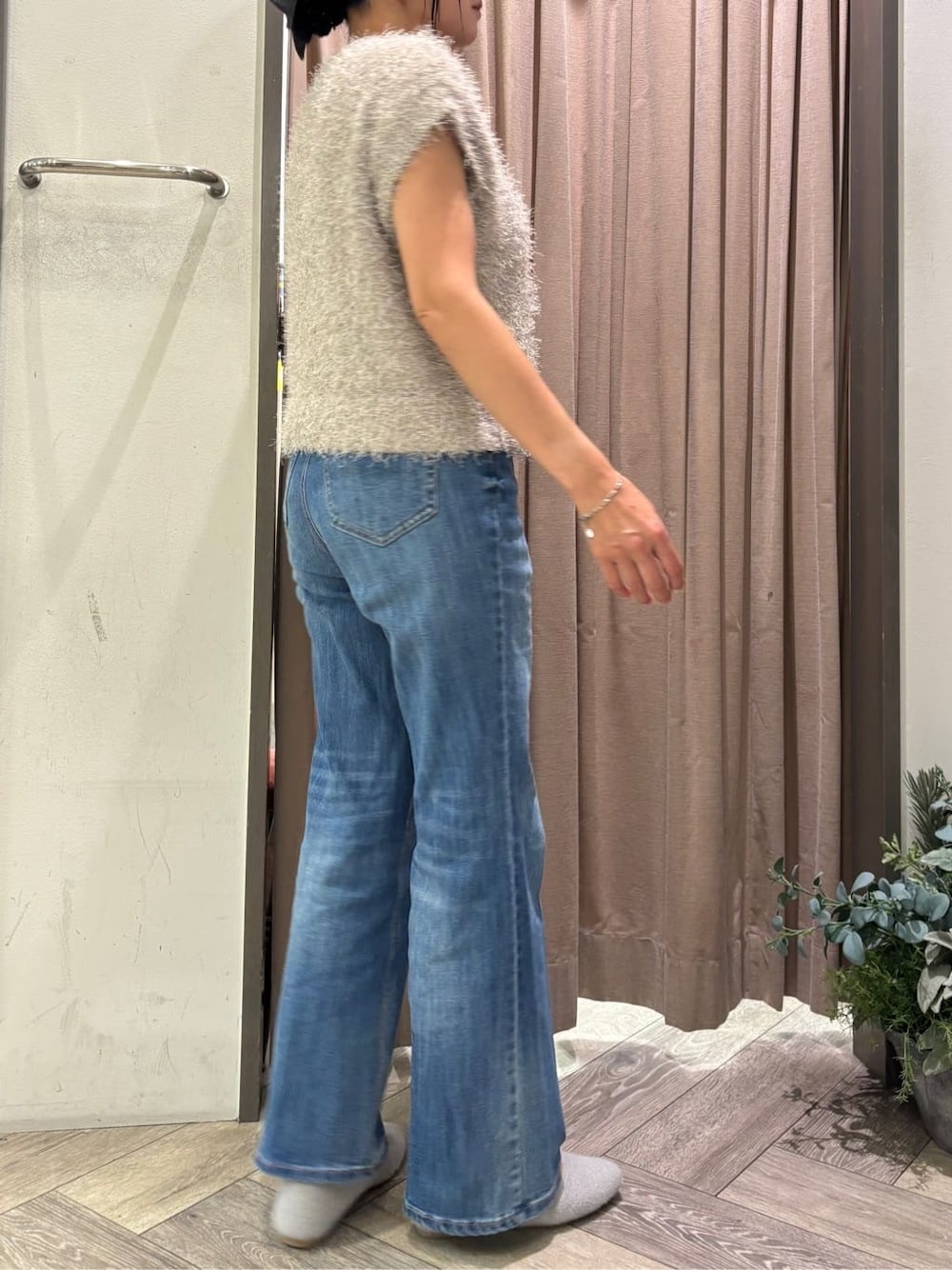 ベージュ系のニット/セーター、ブルー系のデニムパンツ、シルバー系のネックレスを着用したレディースの秋コーディネートの2枚目の写真
