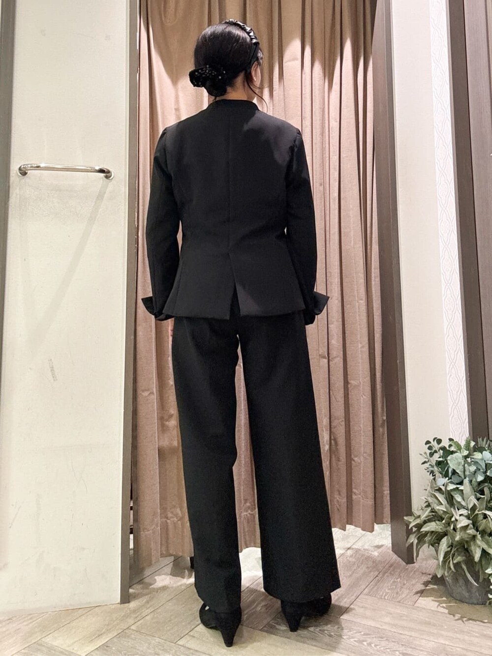 ブラック系のノーカラージャケット、ブラック系のワンピース、ブラック系のその他パンツを着用したレディースの冬コーディネートの4枚目の写真
