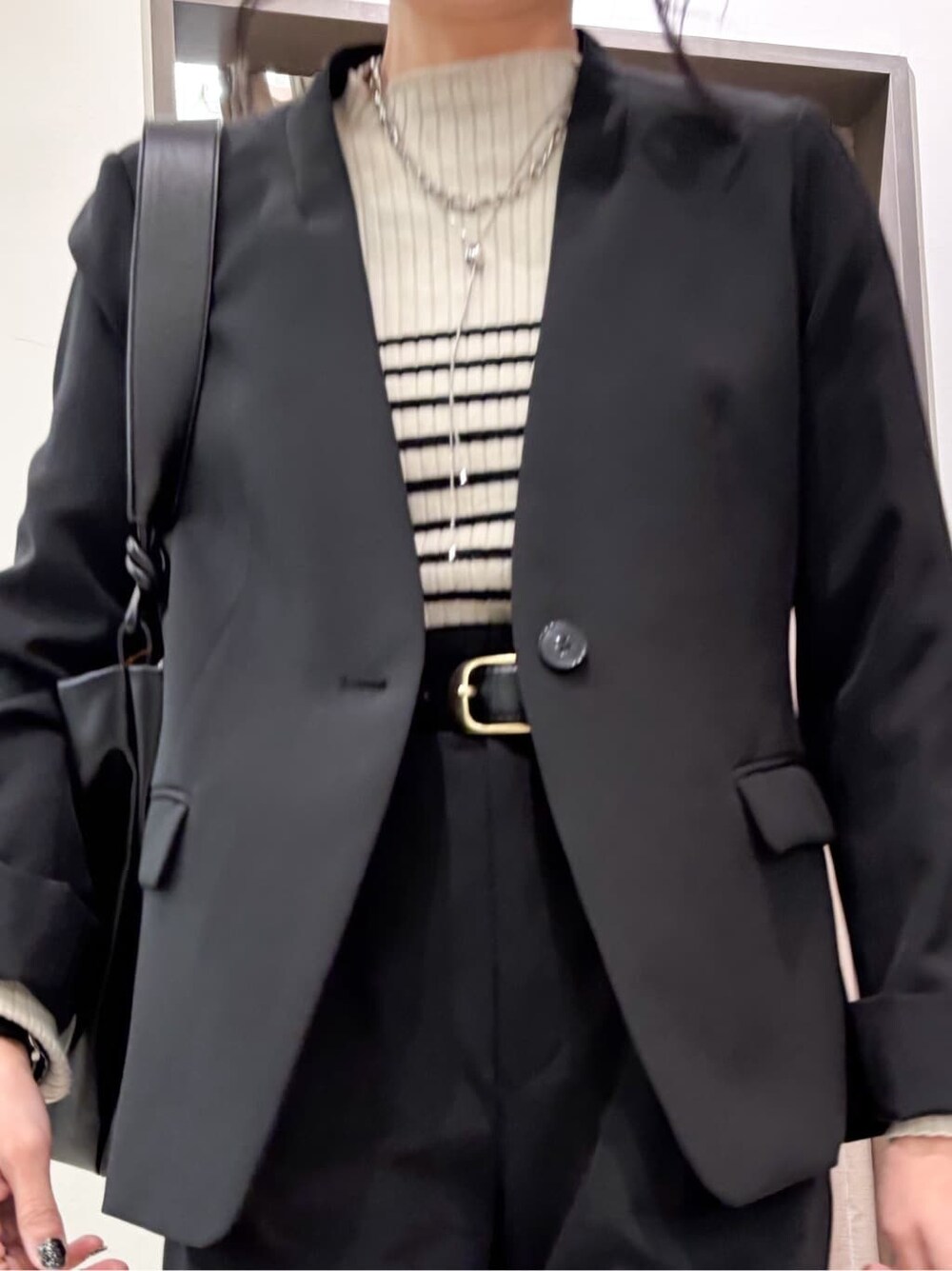 ブラック系のノーカラージャケット、ブラック系のワンピース、ブラック系のその他パンツを着用したレディースの冬コーディネートの7枚目の写真