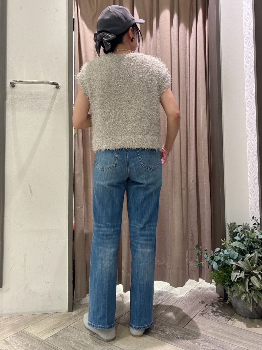 ベージュ系のニット/セーター、ブルー系のデニムパンツ、シルバー系のネックレスを着用したレディースの秋コーディネートの3枚目の写真