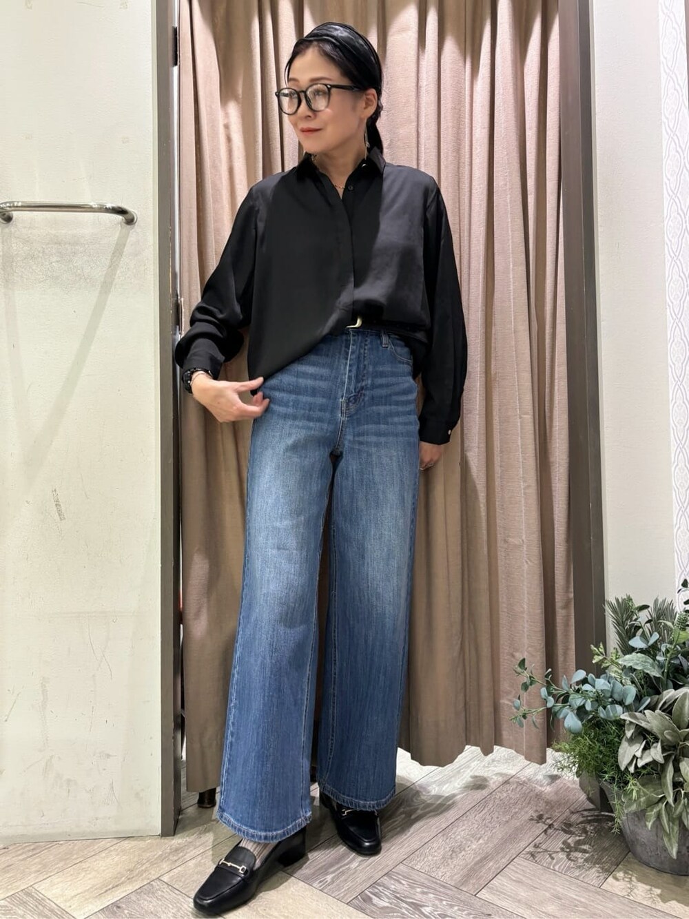 ブラック系のシャツ/ブラウス、ブルー系のデニムパンツ、ブラック系のベルトを着用したレディースの秋コーディネートの2枚目の写真