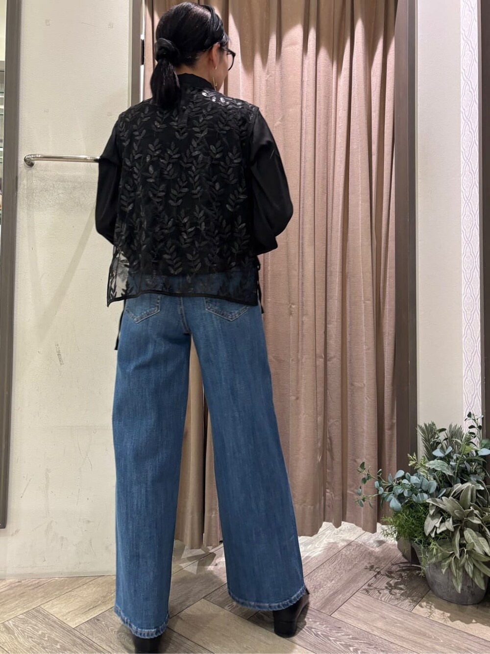 ブラック系のシャツ/ブラウス、ブルー系のデニムパンツ、ブラック系のベルトを着用したレディースの秋コーディネートの4枚目の写真