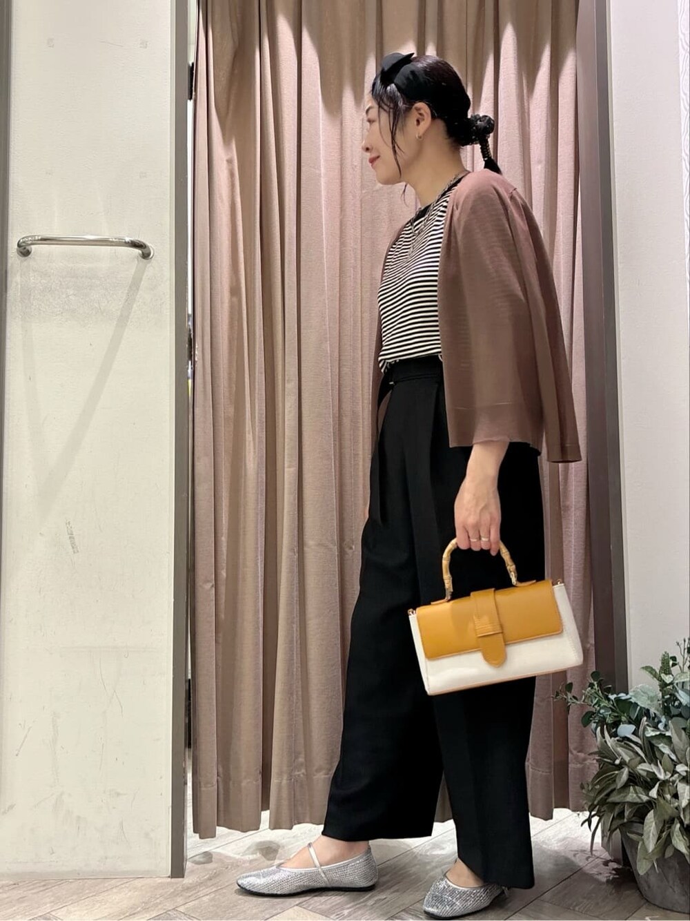 ブラウン系のカーディガン/ボレロ、ブラック系のニット/セーター、ブラック系のその他パンツを着用したレディースの春コーディネートの3枚目の写真