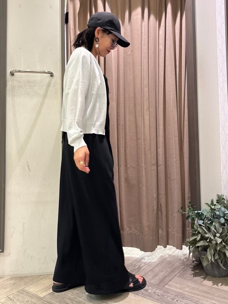 ホワイト系のカーディガン/ボレロ、ホワイト系のTシャツ/カットソー、ブラック系のサロペット/オーバーオールを着用したレディースの春コーディネートの4枚目の写真