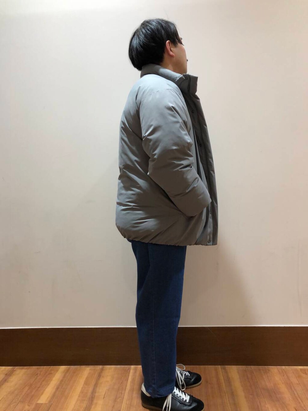 グレー系のダウンジャケット/コート、ブルー系のその他パンツ、ホワイト系のTシャツ/カットソーを着用したメンズの冬コーディネートの2枚目の写真