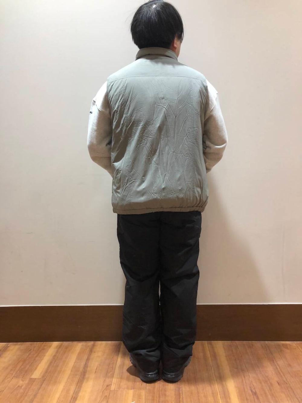 グリーン系のダウンベスト、ブラック系のその他パンツ、ブラック系のスニーカーを着用したメンズの冬コーディネートの3枚目の写真