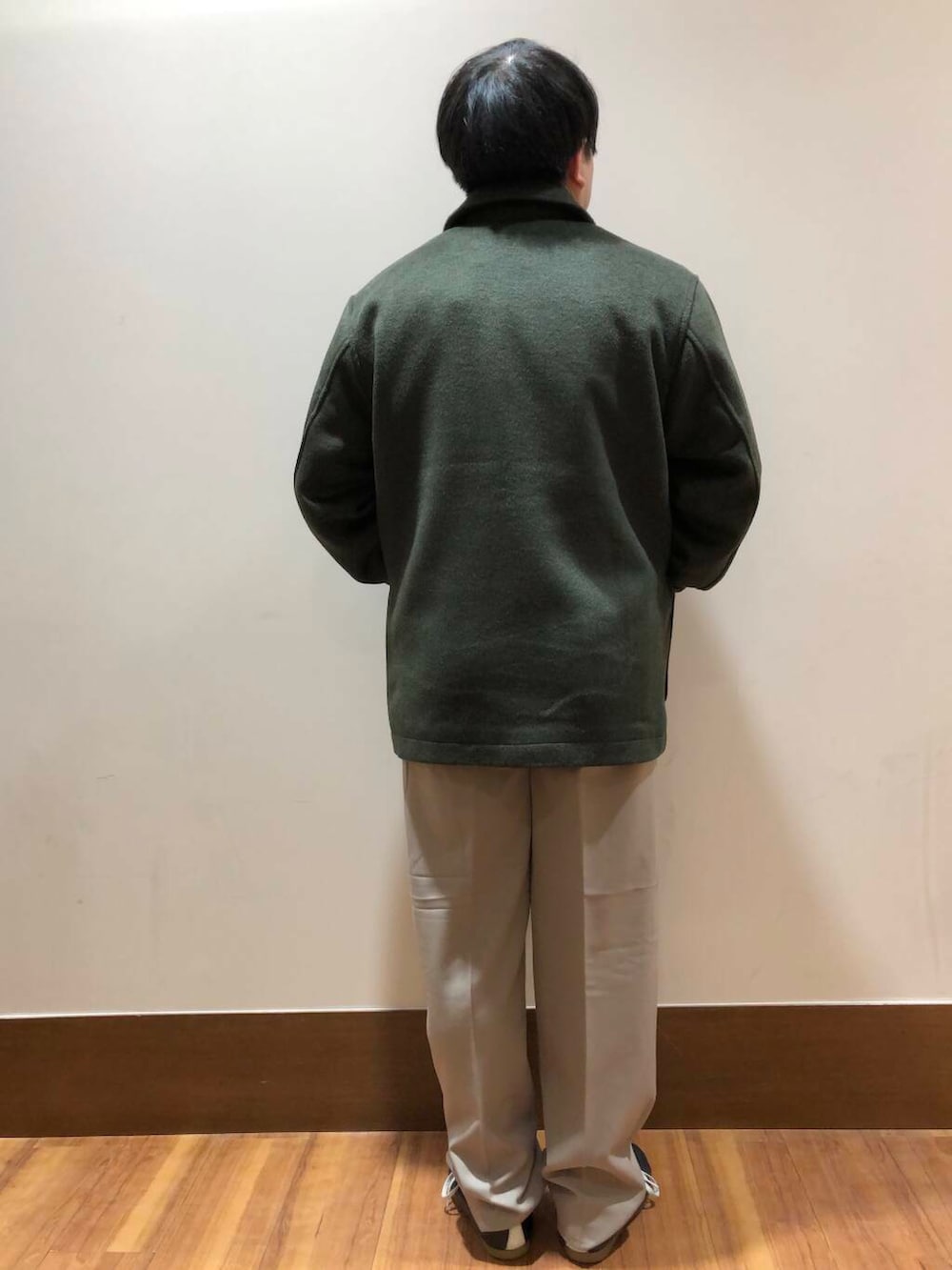 ベージュ系のその他パンツ、ブラック系のニット/セーター、グリーン系のステンカラーコートを着用したメンズの冬コーディネートの3枚目の写真