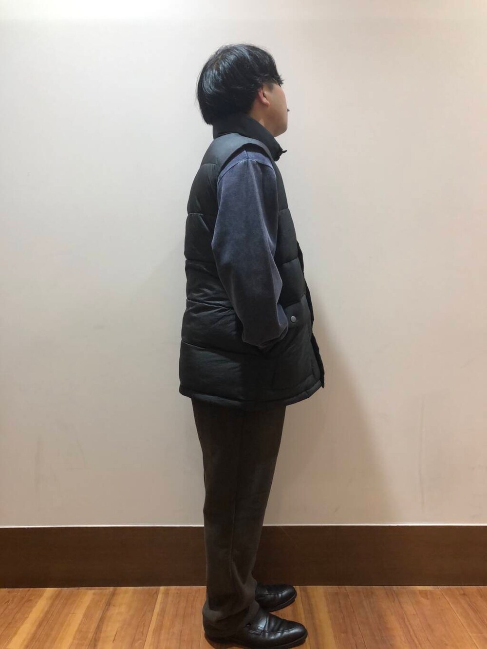 ブラウン系のその他パンツ、ブラック系のダウンベスト、ブルー系のスウェットを着用したメンズの秋コーディネートの2枚目の写真