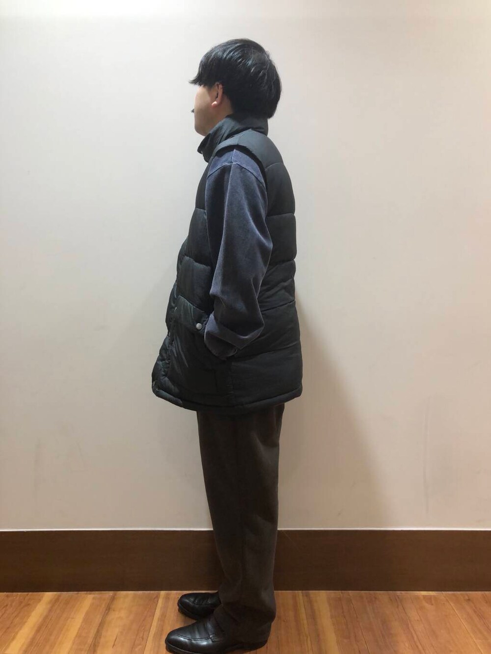 ブラウン系のその他パンツ、ブラック系のダウンベスト、ブルー系のスウェットを着用したメンズの秋コーディネートの4枚目の写真