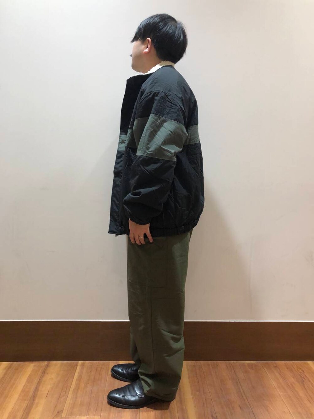 グリーン系のその他パンツ、ブラック系のナイロンジャケット、ベージュ系のスウェットを着用したメンズの冬コーディネートの4枚目の写真