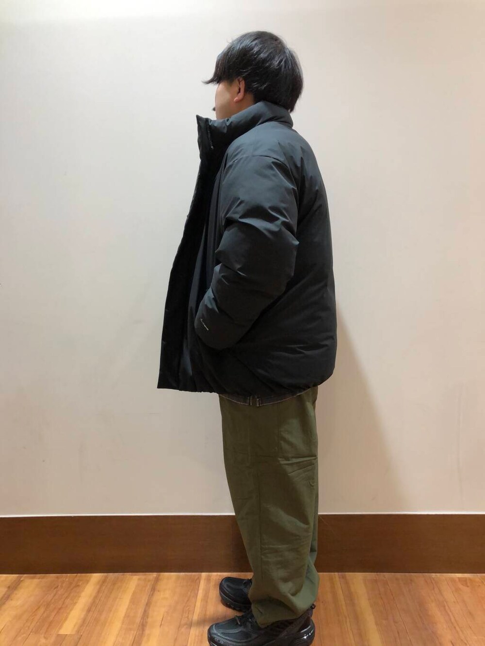 グリーン系のその他パンツ、ブラック系のダウンジャケット/コート、ブラック系のスニーカーを着用したメンズの冬コーディネートの4枚目の写真