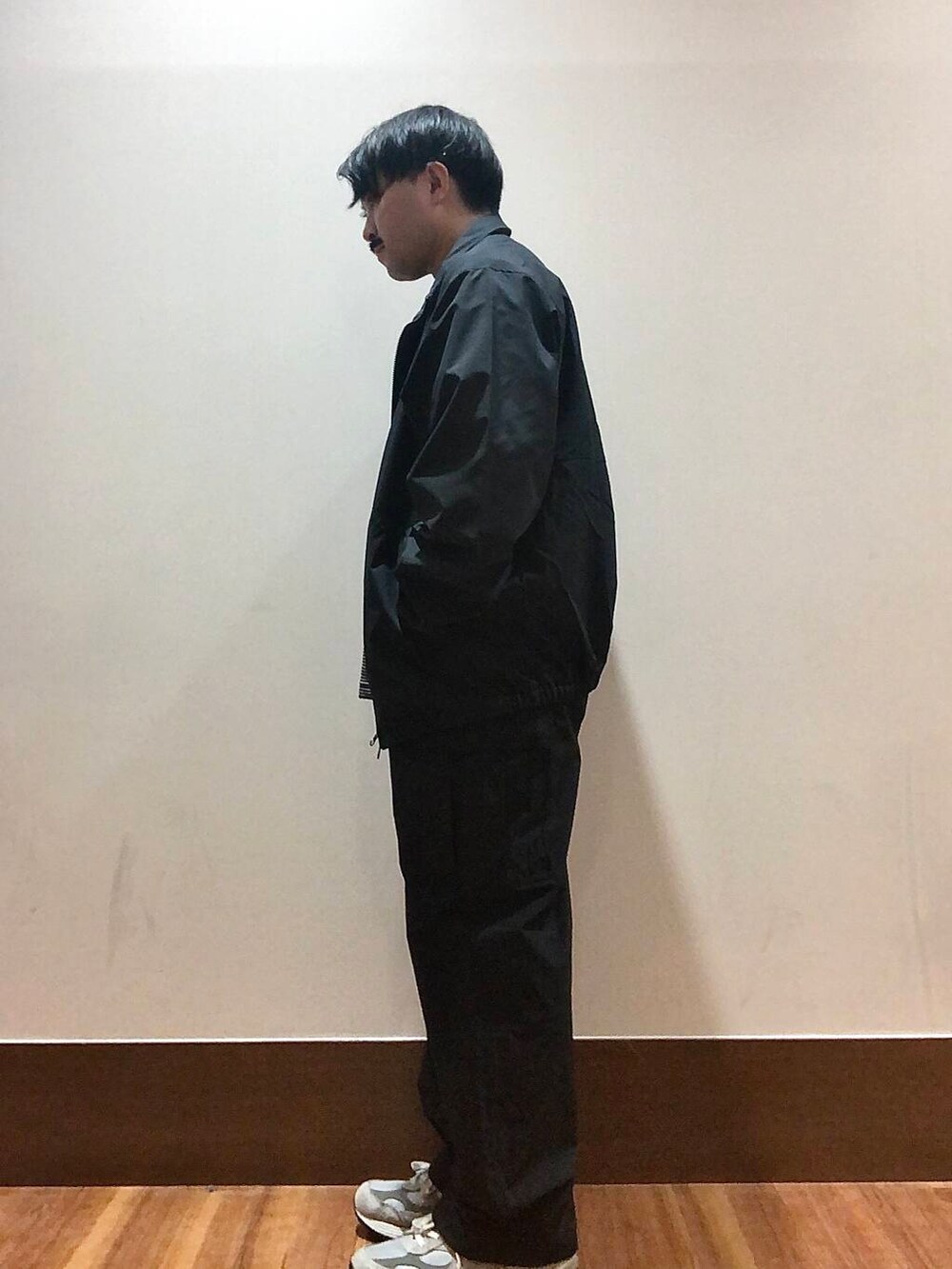 ブラック系のTシャツ/カットソー、ブラック系のブルゾン、ブラック系のカーゴパンツを着用したメンズの秋コーディネートの4枚目の写真