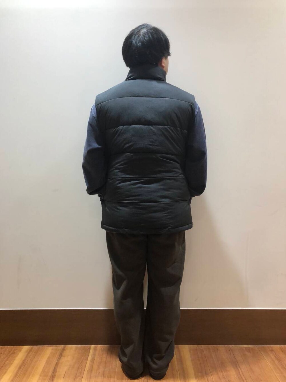 ブラウン系のその他パンツ、ブラック系のダウンベスト、ブルー系のスウェットを着用したメンズの秋コーディネートの3枚目の写真