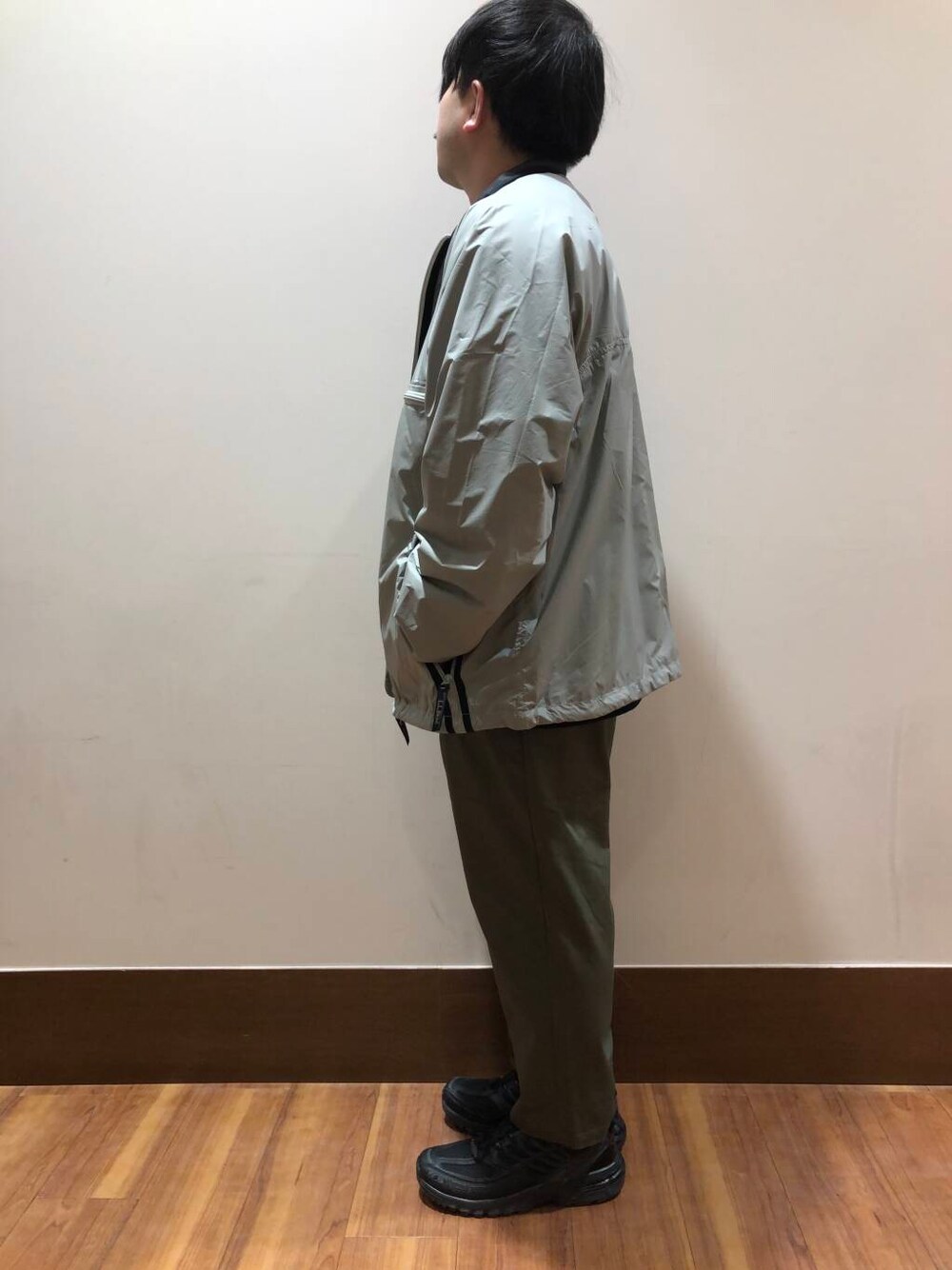 ブラック系のスニーカー、グリーン系のその他パンツ、グレー系のテーラードジャケットを着用したメンズの冬コーディネートの4枚目の写真