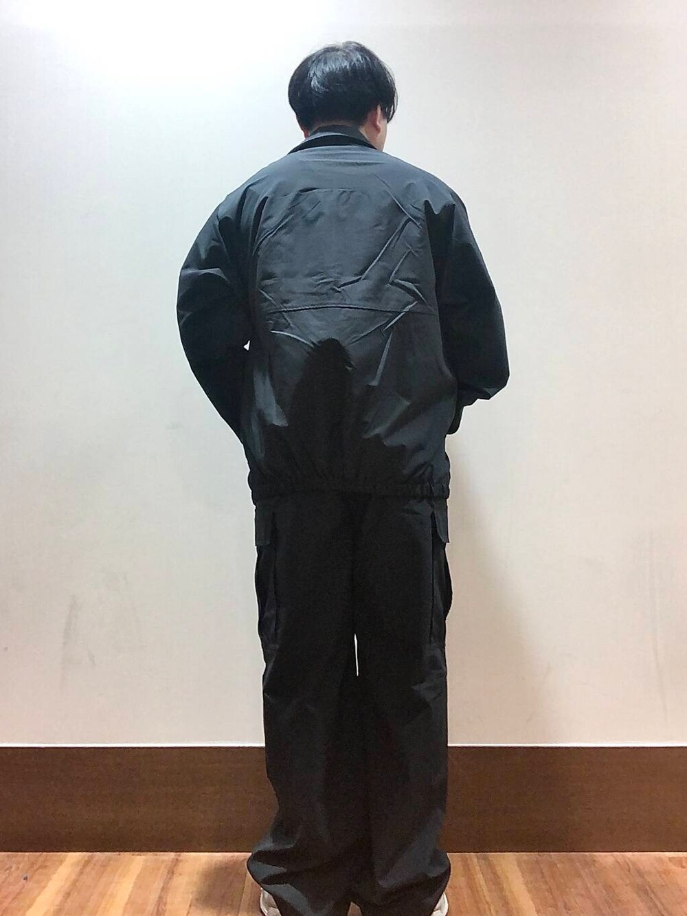 ブラック系のTシャツ/カットソー、ブラック系のブルゾン、ブラック系のカーゴパンツを着用したメンズの秋コーディネートの3枚目の写真