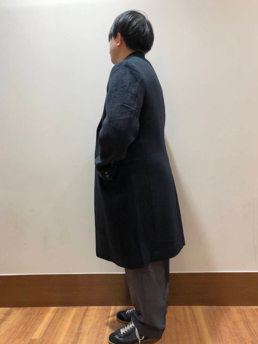 グレー系のその他パンツ、オレンジ系のニット/セーター、ブラック系のその他アウターを着用したメンズの冬コーディネートの4枚目の写真