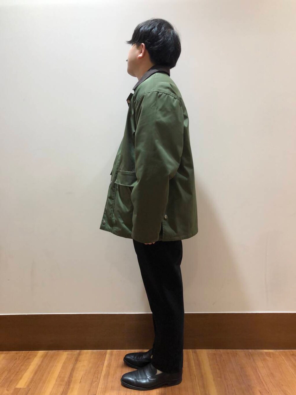 グリーン系のミリタリージャケット、ベージュ系のスウェット、ブラック系のその他パンツを着用したメンズの秋コーディネートの4枚目の写真