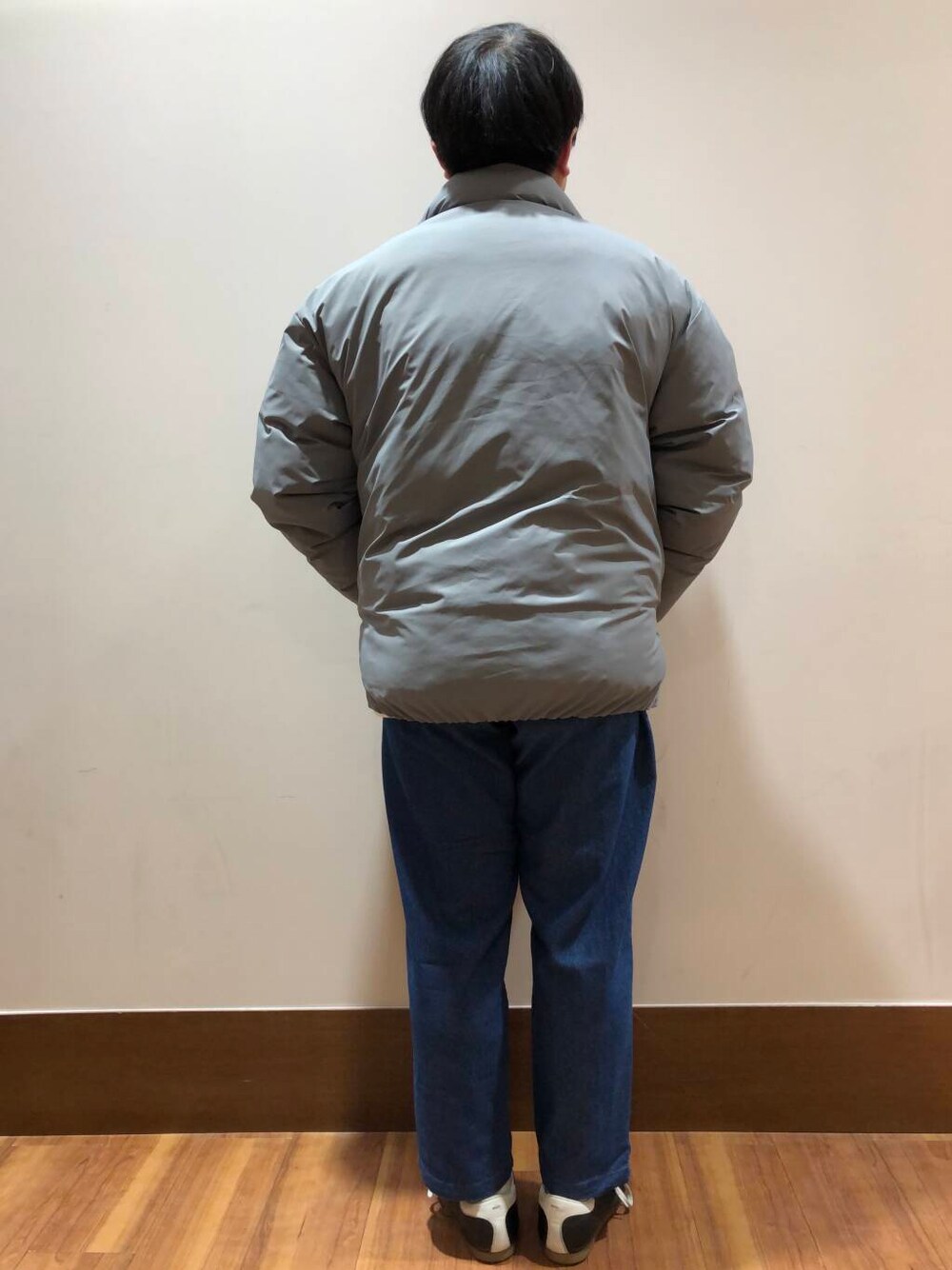 グレー系のダウンジャケット/コート、ブルー系のその他パンツ、ホワイト系のTシャツ/カットソーを着用したメンズの冬コーディネートの3枚目の写真