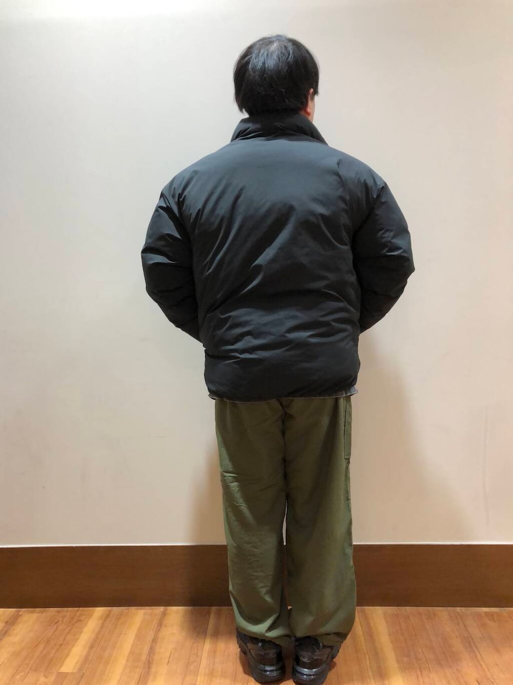 グリーン系のその他パンツ、ブラック系のダウンジャケット/コート、ブラック系のスニーカーを着用したメンズの冬コーディネートの3枚目の写真