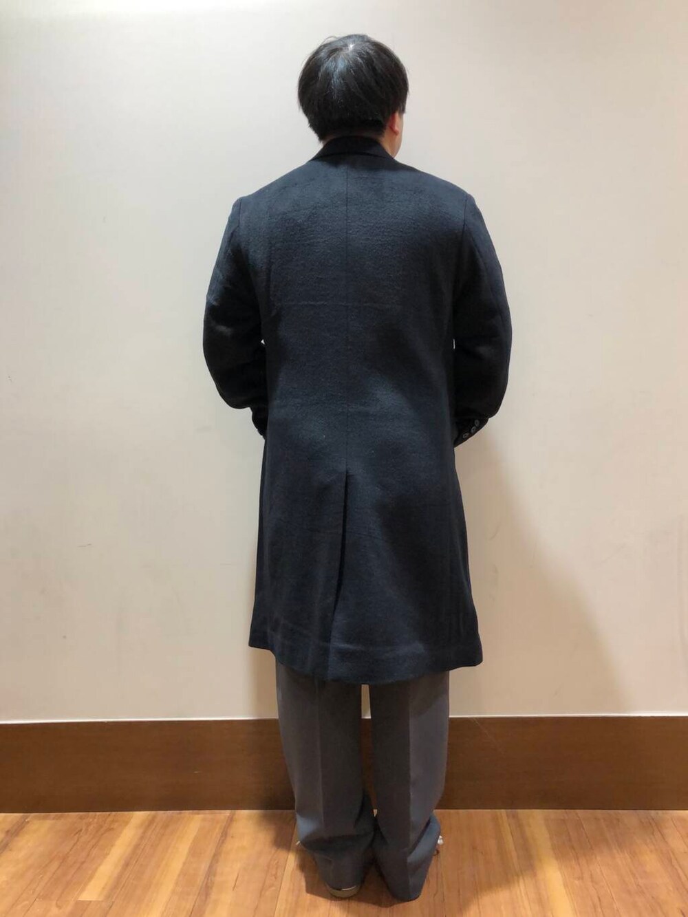 グレー系のその他パンツ、オレンジ系のニット/セーター、ブラック系のその他アウターを着用したメンズの冬コーディネートの3枚目の写真