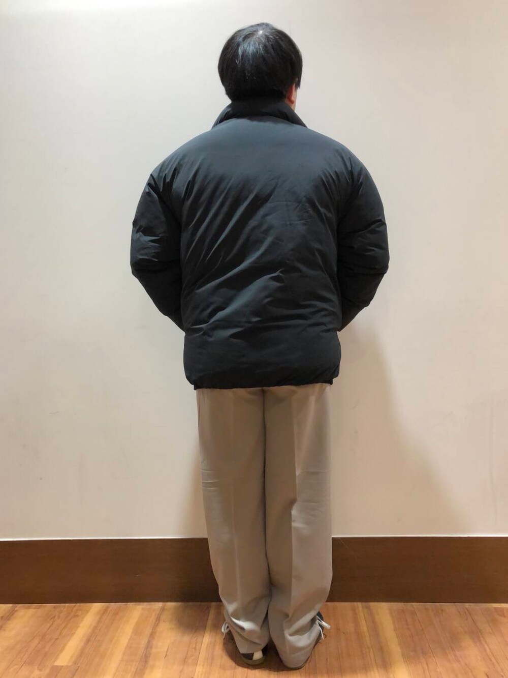 ベージュ系のその他パンツ、ブラック系のダウンジャケット/コート、ブラック系のニット/セーターを着用したメンズの冬コーディネートの3枚目の写真