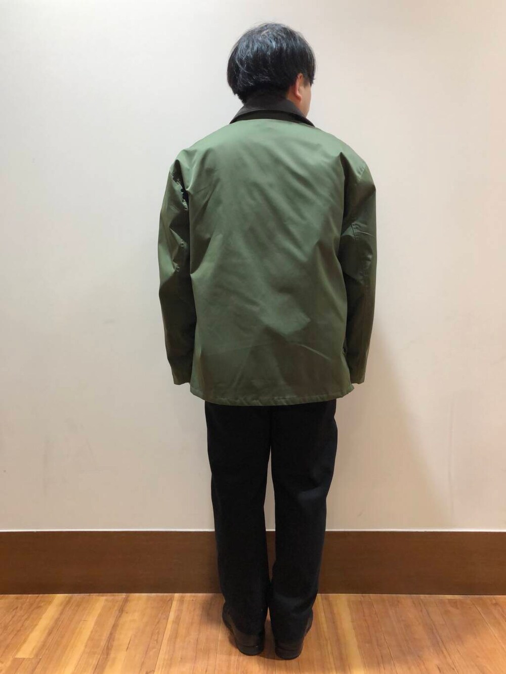 グリーン系のミリタリージャケット、ベージュ系のスウェット、ブラック系のその他パンツを着用したメンズの秋コーディネートの3枚目の写真