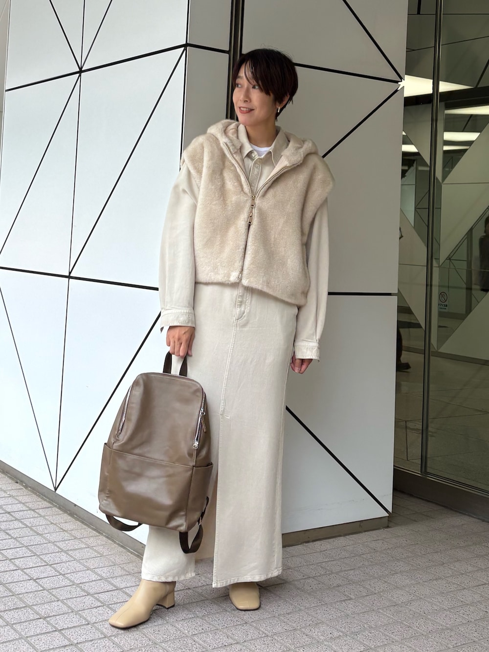 ホワイト系のスカート、ホワイト系のベスト、ホワイト系のシャツ/ブラウスを着用したレディースの秋コーディネートの3枚目の写真