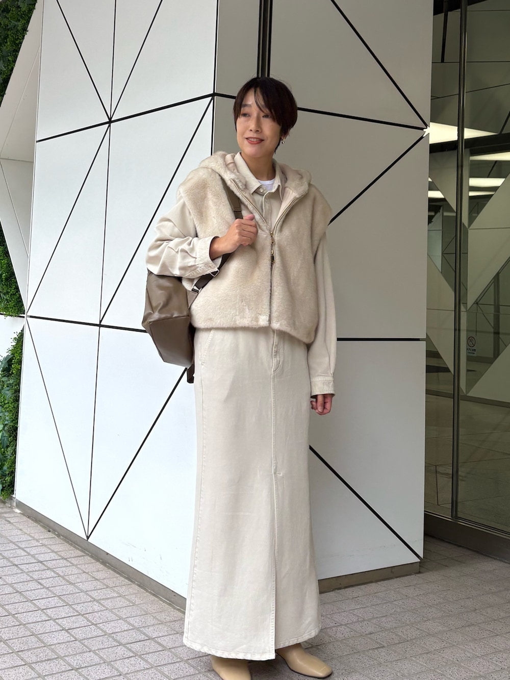 ホワイト系のスカート、ホワイト系のベスト、ホワイト系のシャツ/ブラウスを着用したレディースの秋コーディネートの2枚目の写真