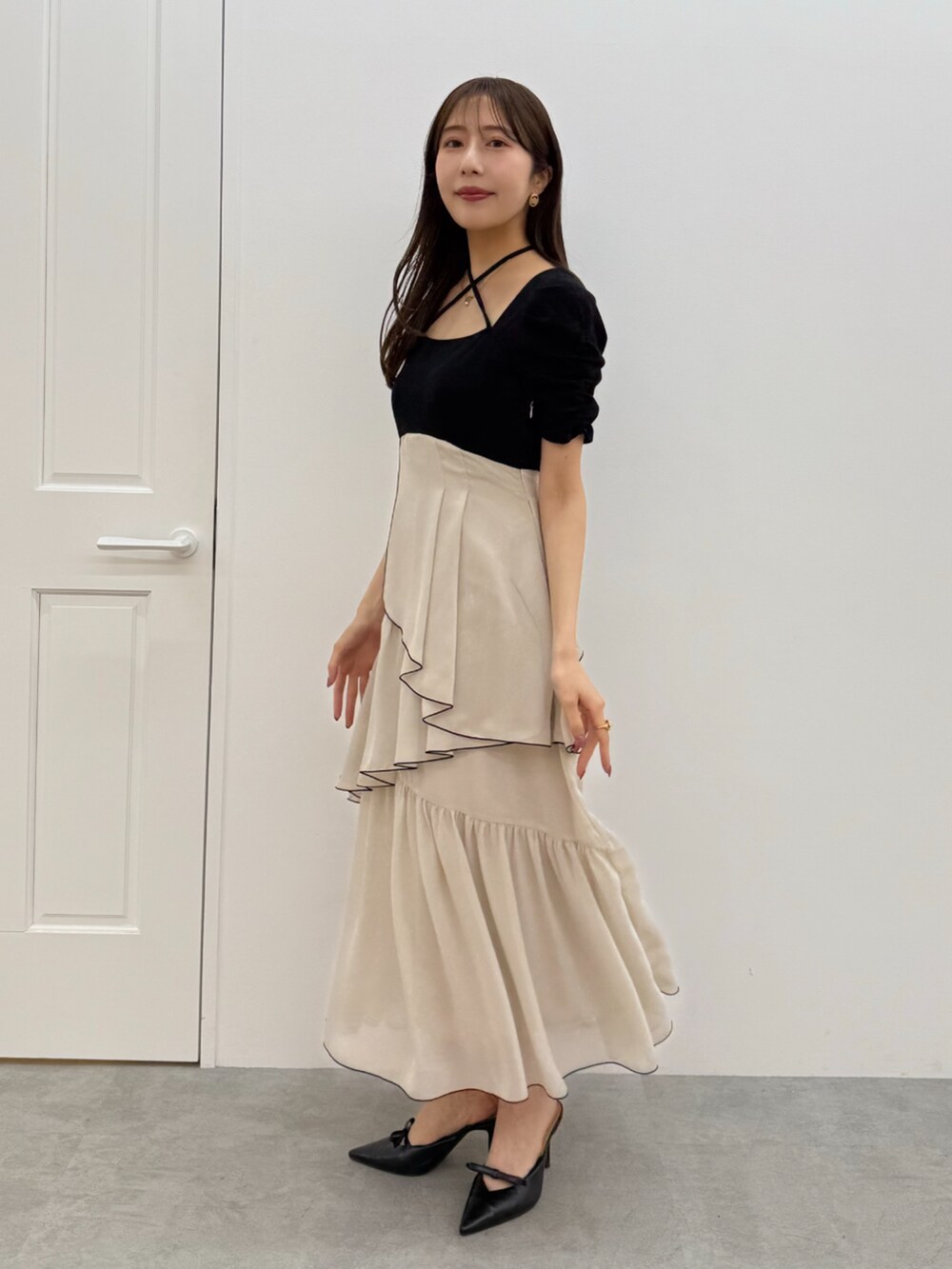 ブラック系のワンピース、ブラック系のパンプスを着用したレディースの春コーディネートの3枚目の写真