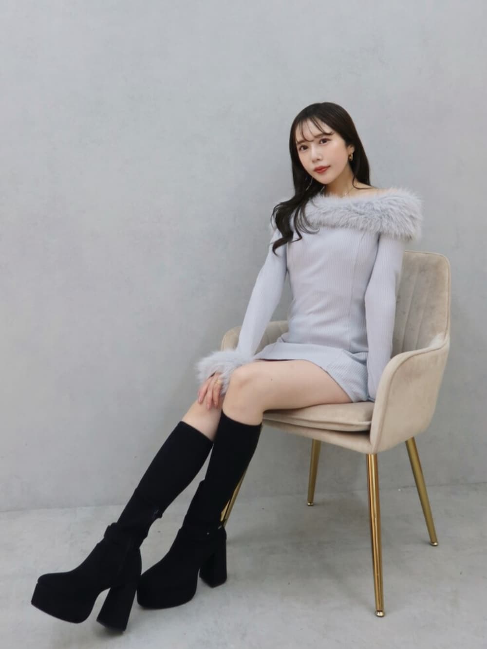 ブラック系のブーツ、グレー系のワンピースを着用したレディースの秋コーディネートの2枚目の写真