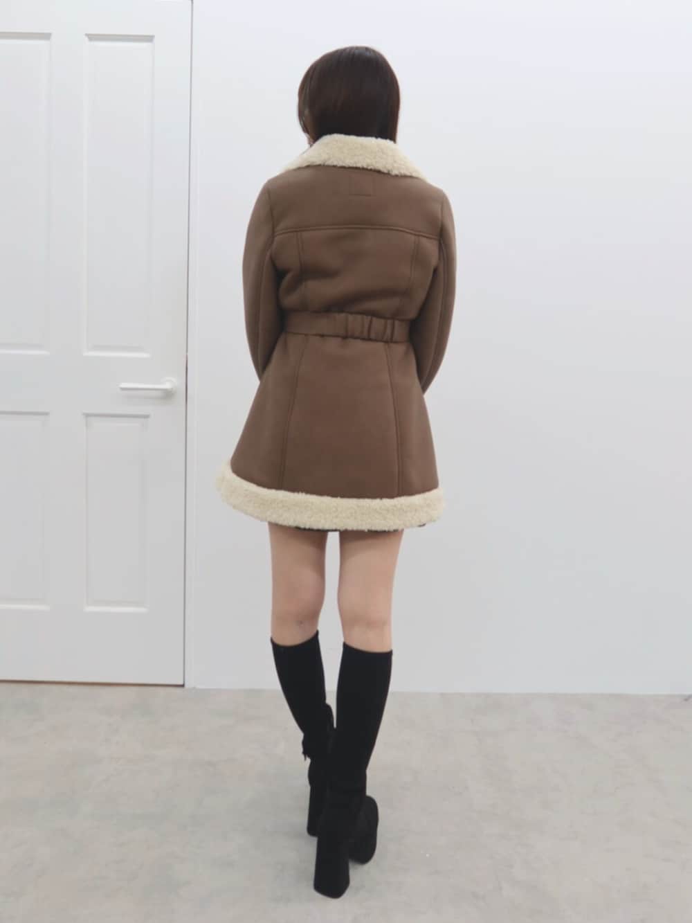 ブラック系のブーツ、ブラウン系のムートンコートを着用したレディースの秋コーディネートの4枚目の写真