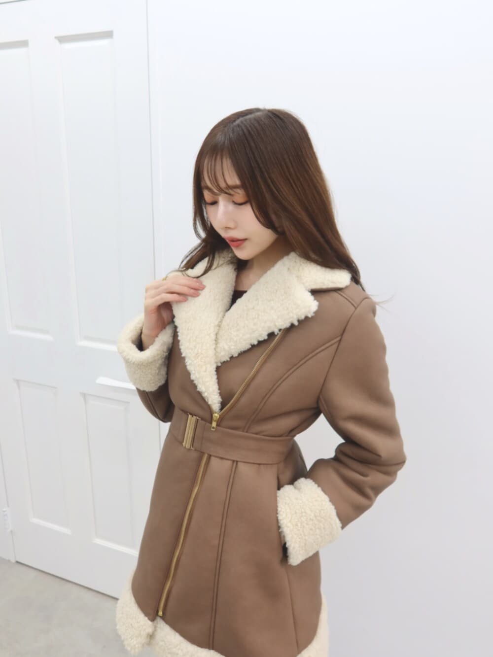 ブラック系のブーツ、ブラウン系のムートンコートを着用したレディースの秋コーディネートの2枚目の写真