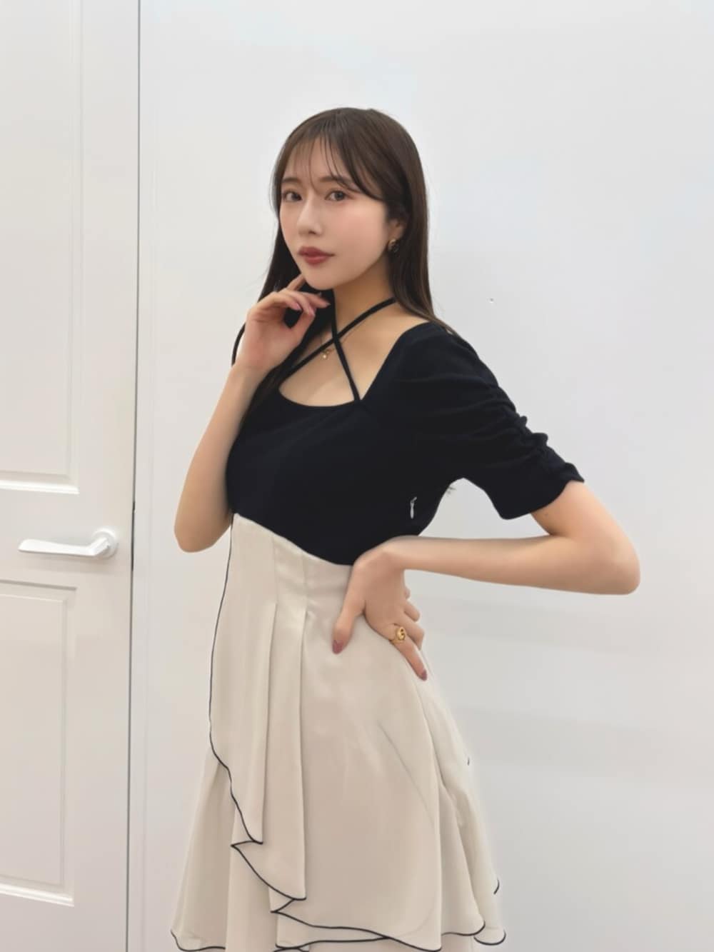 ブラック系のワンピース、ブラック系のパンプスを着用したレディースの春コーディネートの2枚目の写真