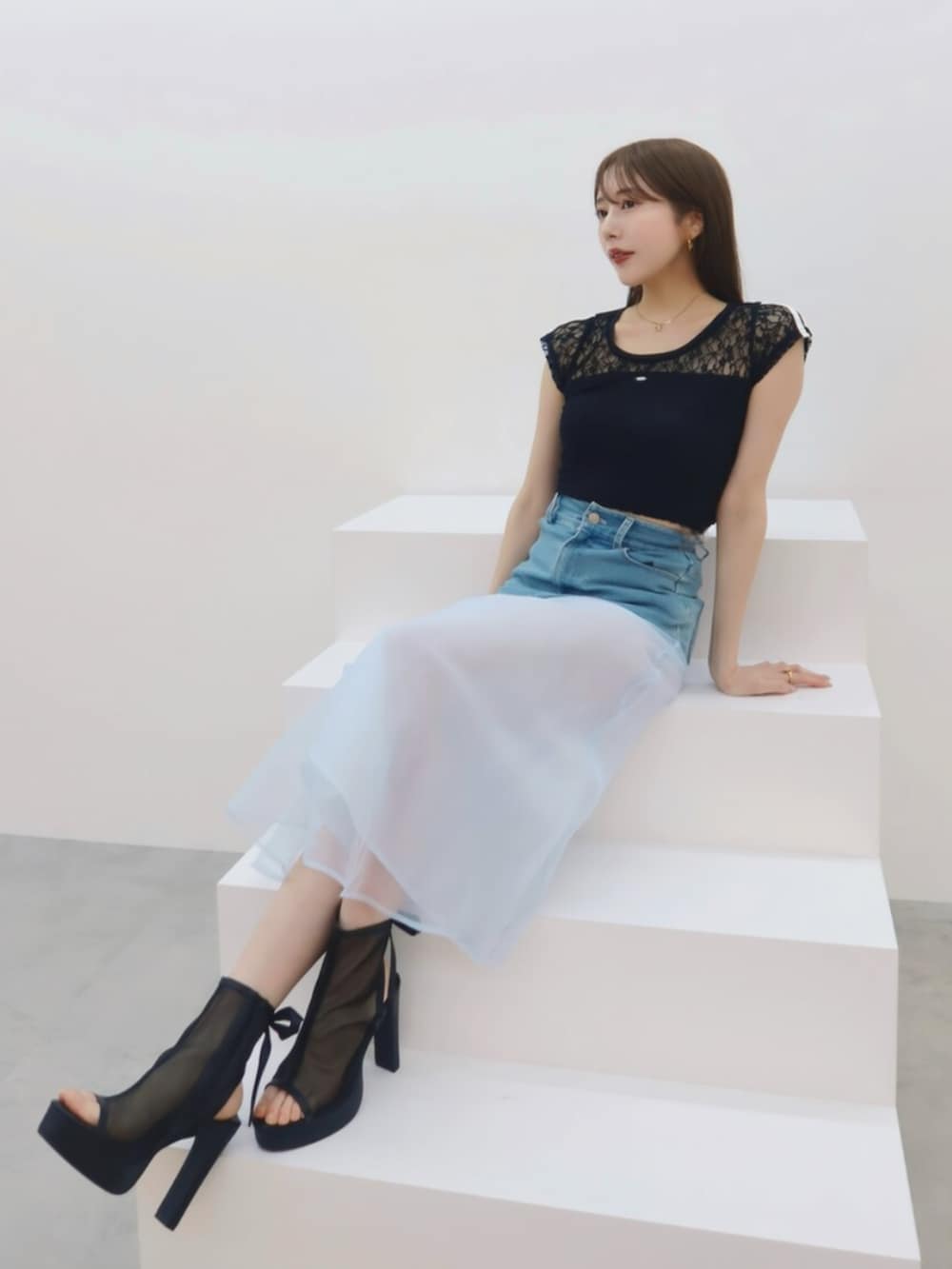 ブラック系のTシャツ/カットソー、ブルー系のデニムスカートを着用したレディースの春コーディネートの3枚目の写真