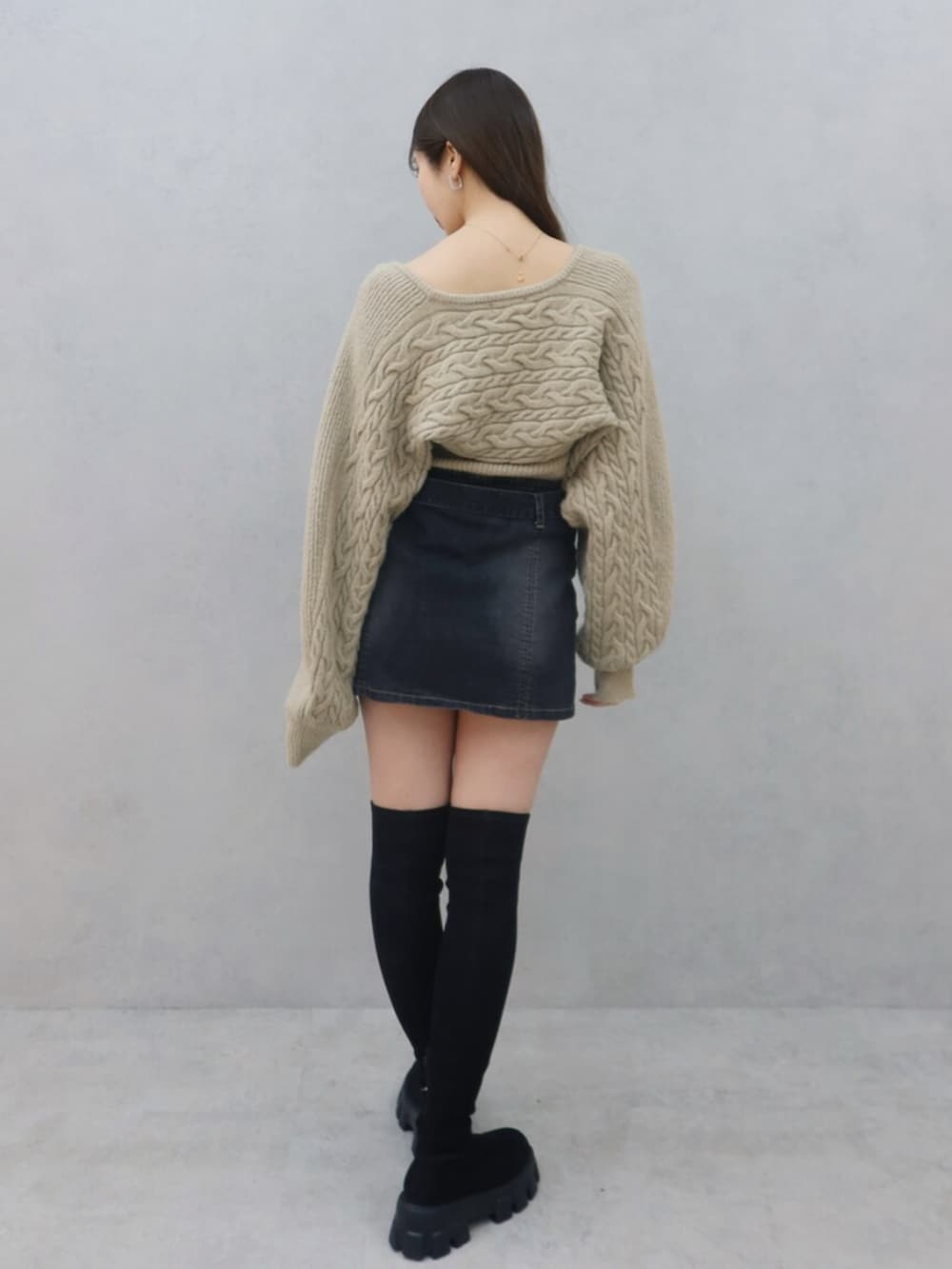 ベージュ系のニット/セーター、ブラック系のデニムスカート、ブラック系のブーツを着用したレディースの冬コーディネートの4枚目の写真