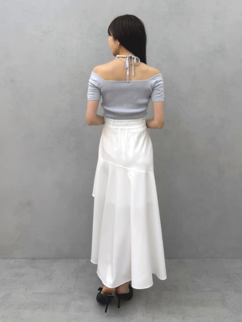 ブルー系のニット/セーター、ホワイト系のスカート、ブラック系のパンプスを着用したレディースの春コーディネートの3枚目の写真