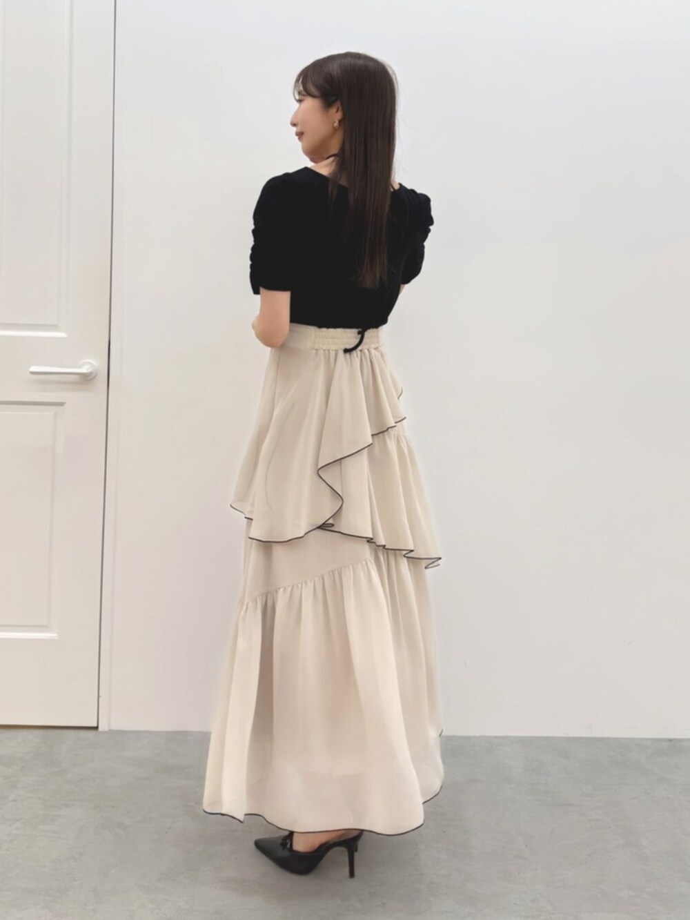 ブラック系のワンピース、ブラック系のパンプスを着用したレディースの春コーディネートの4枚目の写真