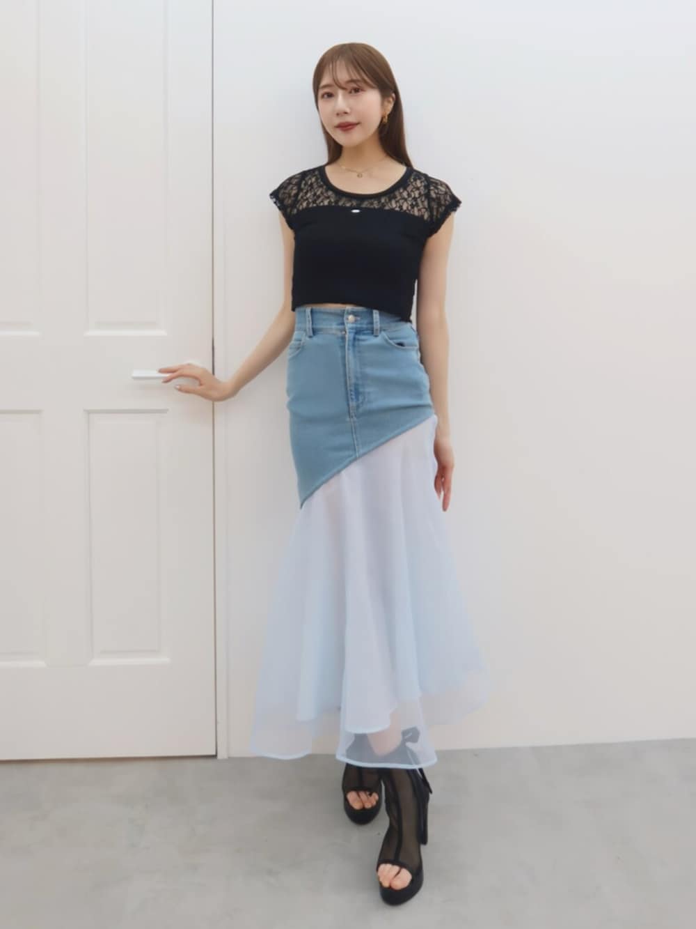 ブラック系のTシャツ/カットソー、ブルー系のデニムスカートを着用したレディースの春コーディネートの5枚目の写真