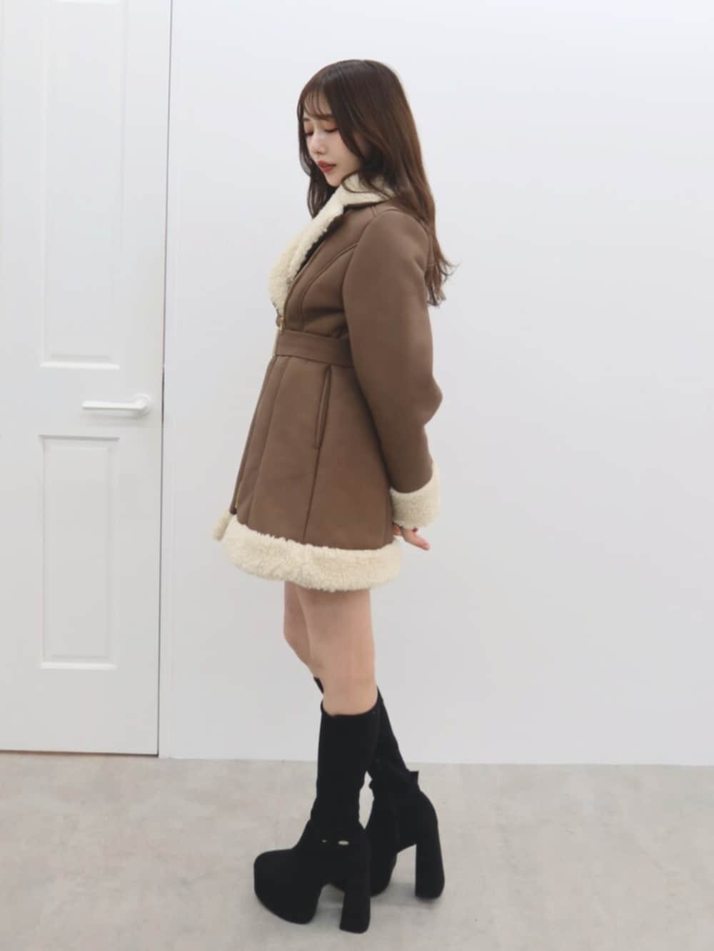 ブラック系のブーツ、ブラウン系のムートンコートを着用したレディースの秋コーディネートの3枚目の写真