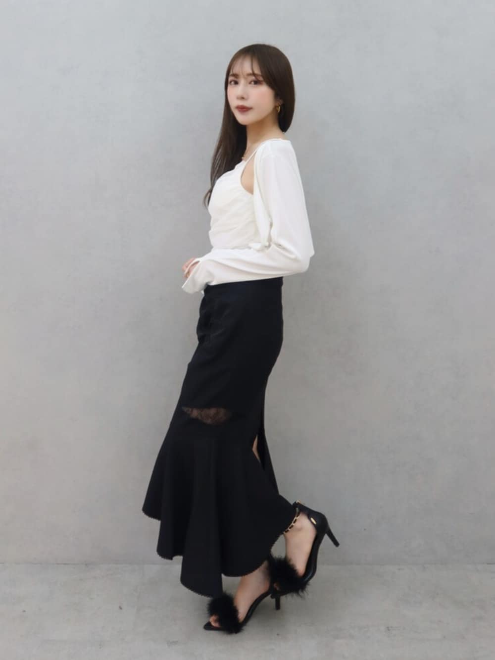 ブラック系のサンダル、ブラック系のスカート、ホワイト系のTシャツ/カットソーを着用したレディースの春コーディネートの2枚目の写真