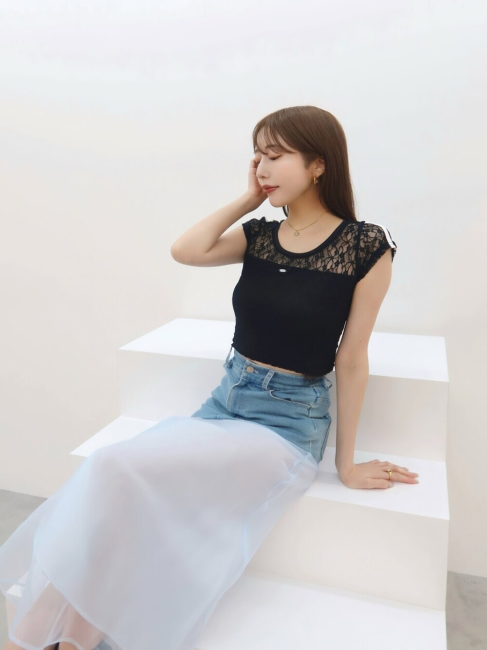 ブラック系のTシャツ/カットソー、ブルー系のデニムスカートを着用したレディースの春コーディネートの2枚目の写真