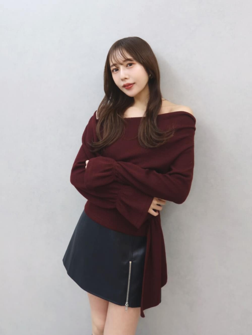 レッド系のTシャツ/カットソー、ブラック系のスカート、ブラック系のブーツを着用したレディースの秋コーディネートの2枚目の写真