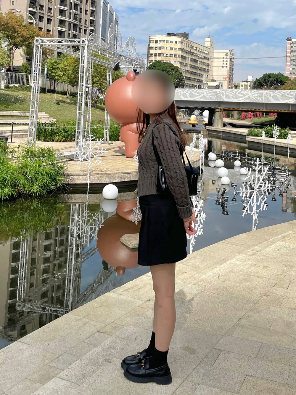 グレー系のニット/セーター、ブラック系のスカート、ブラック系のローファーを着用したレディースの冬コーディネートの2枚目の写真