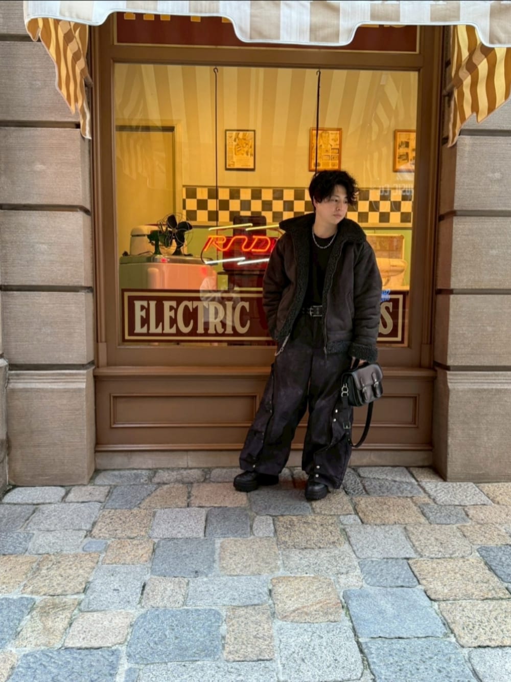 グレー系のムートンコート、ブラック系のスニーカー、ブラック系のその他パンツを着用したメンズの冬コーディネートの2枚目の写真